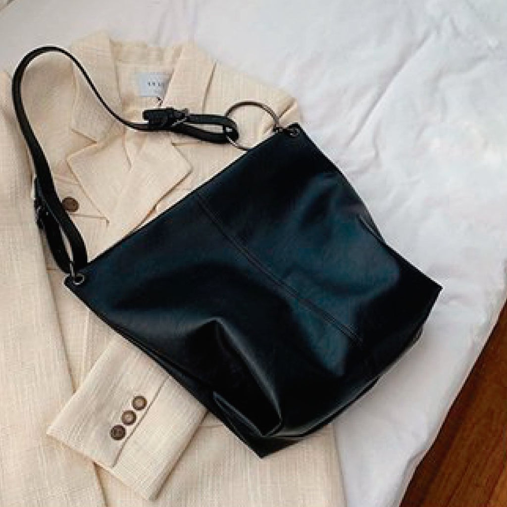 Black slouchy hobo shoulder bag with ring strap and side grommet detail