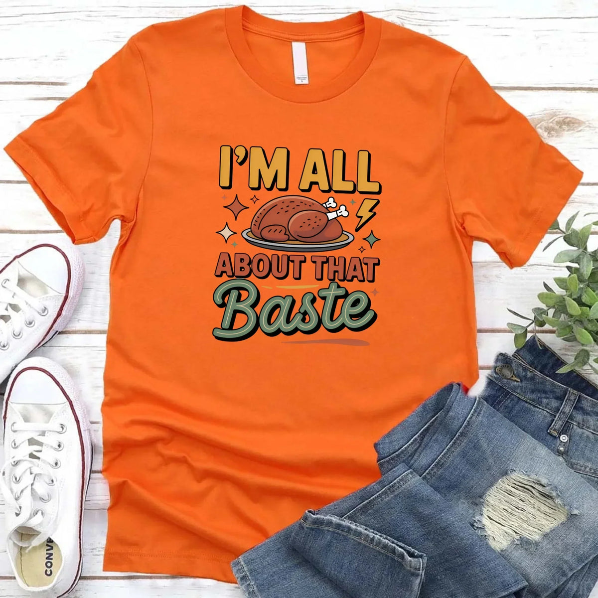 Orange T-shirt with turkey gravy graphic reading “I’m all about that Baste”.