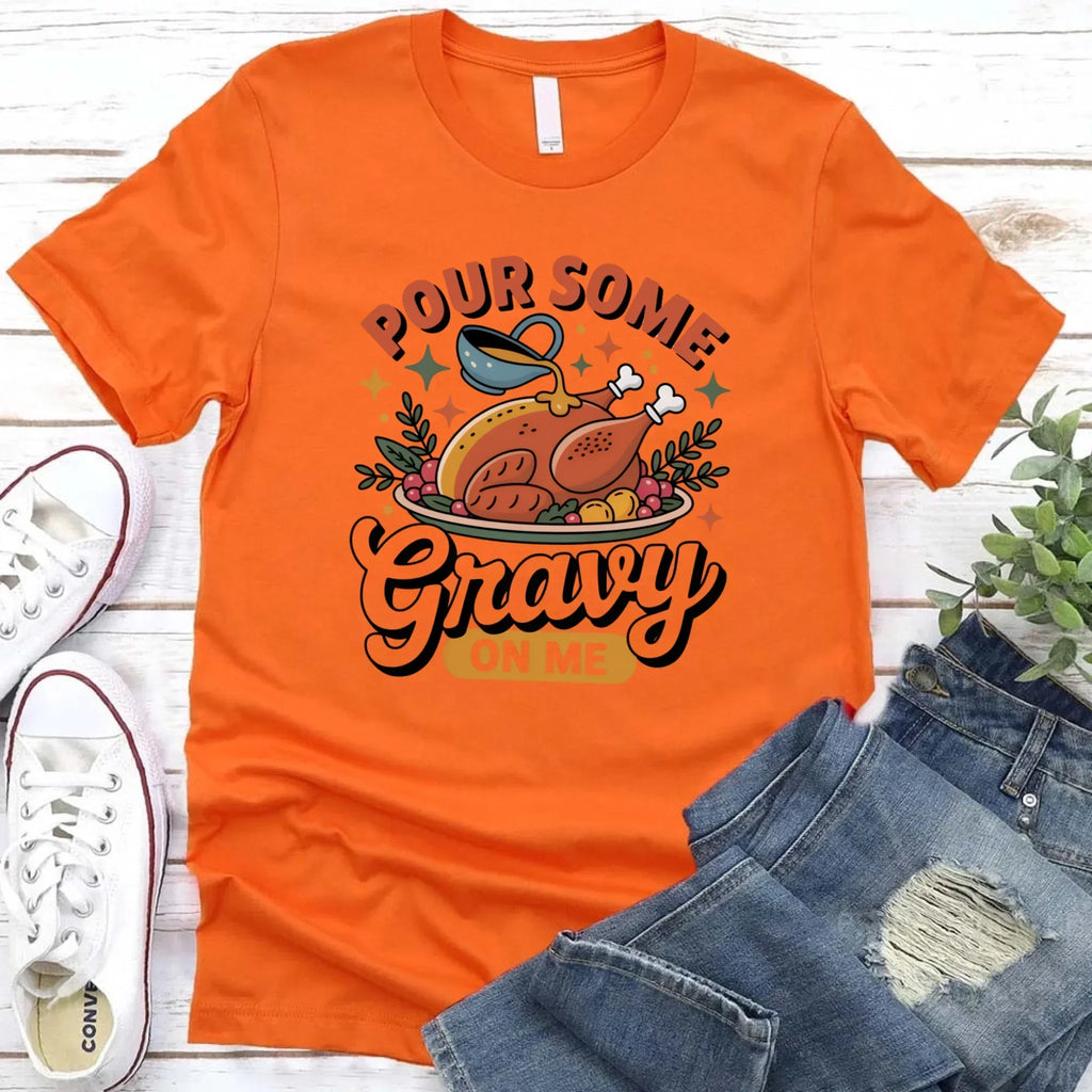 Orange T-shirt with turkey gravy graphic reading “Pour some Gravy on me”.