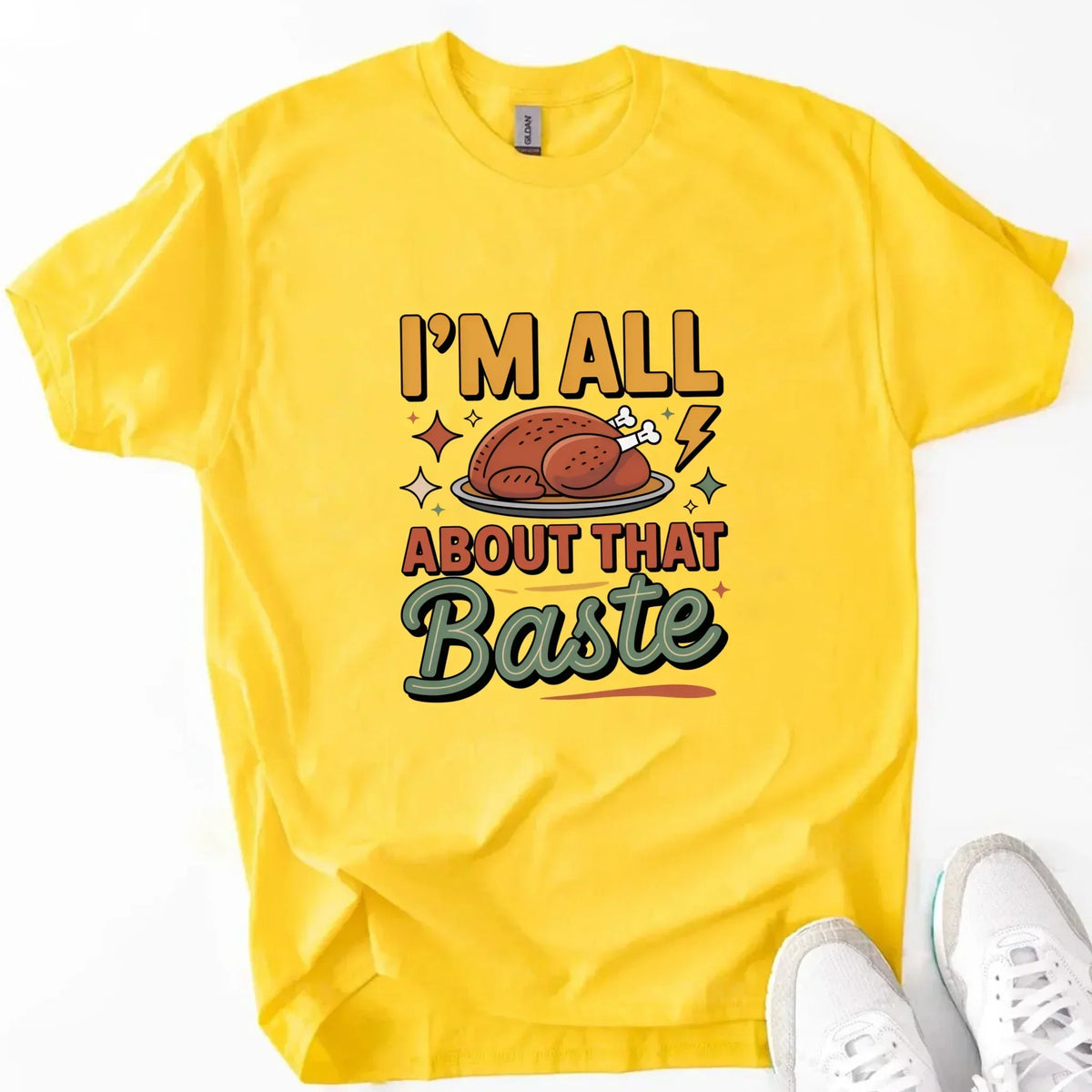 Yellow T-shirt with turkey gravy graphic reading “I’m all about that Baste”.
