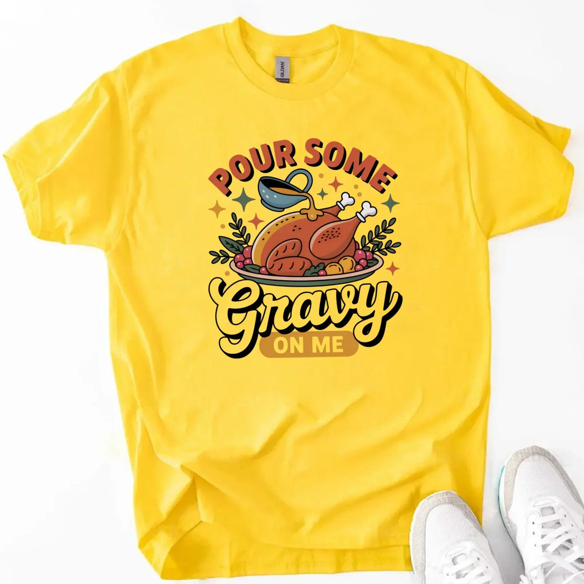 Yellow T-shirt with turkey gravy graphic reading “Pour some Gravy on me”.
