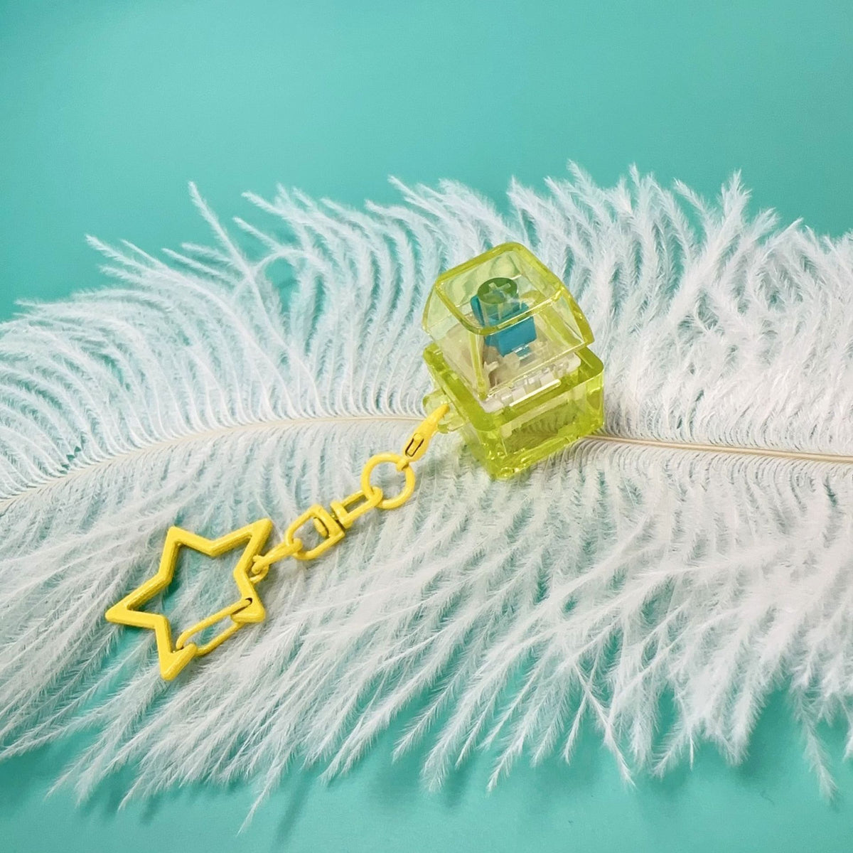 Lime green mechanical key stress-relief toy with clear press piece, yellow star charm