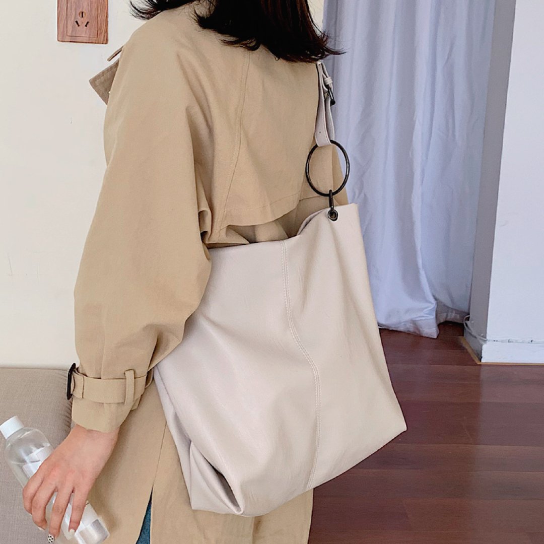 Ivory shoulder bag with ring strap hardware and top zipper closure