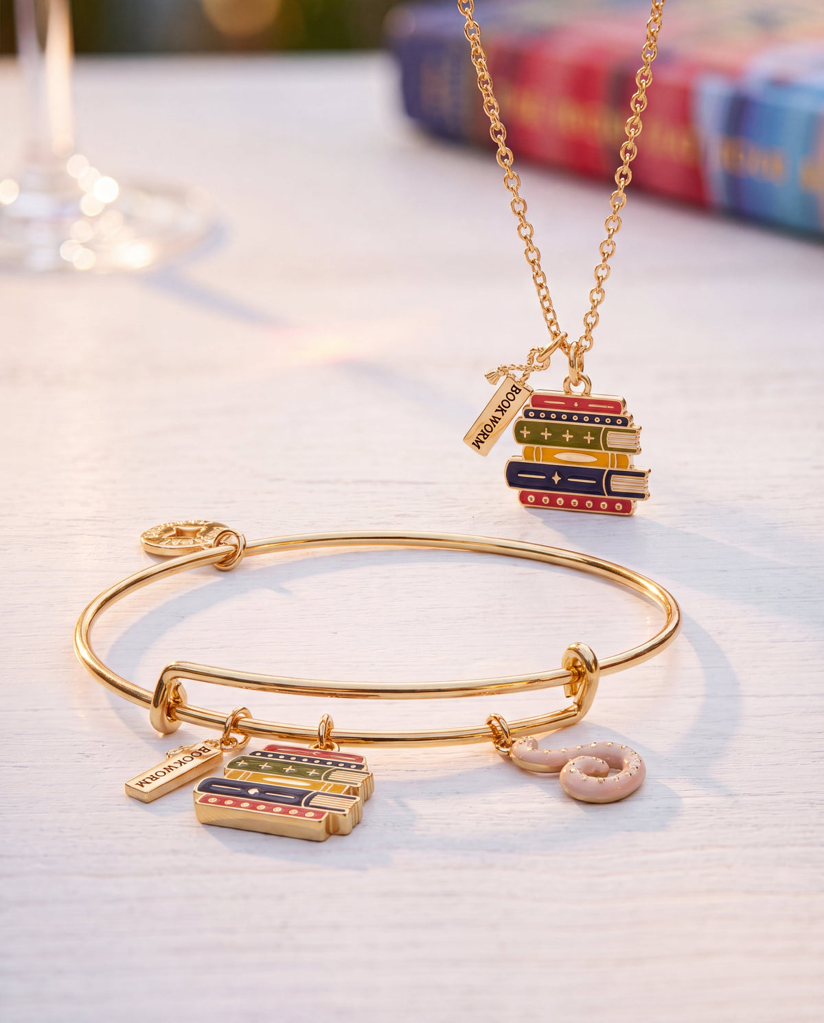 Gold charm bangle with dangling book stack and pink octopus charms