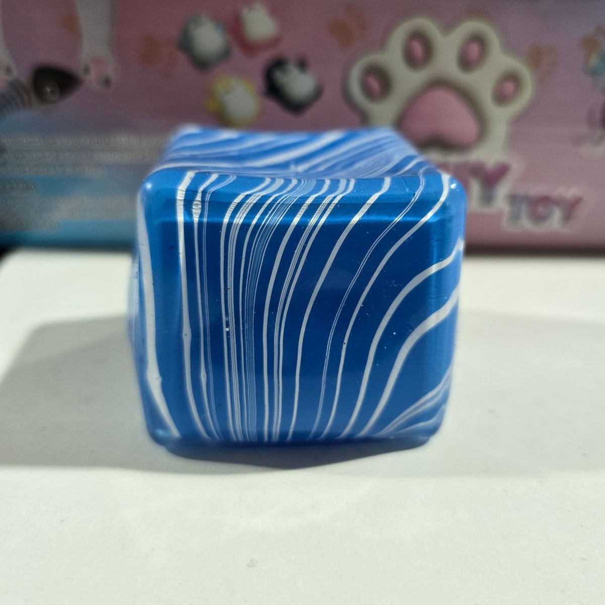 Blue water-cube stress-relief squishy toy with white wavy stripes, translucent