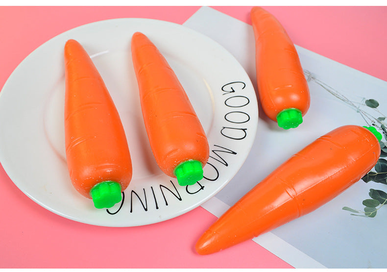 Orange carrot-shaped stress relief toy on a white plate with green cap