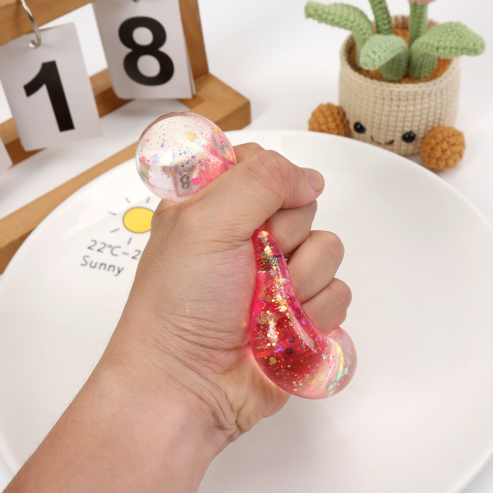 Red-pink glitter heart squeeze stress toy held in a hand