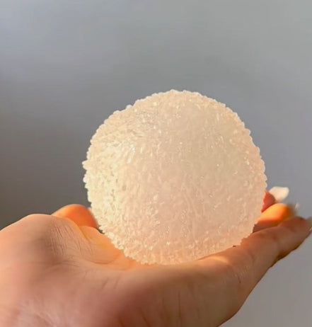 Cream textured bayberry squishy stress toy with stem, held in hand