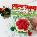 Christmas squishy squeeze toy donut shape, red filling on cream with green sprinkles