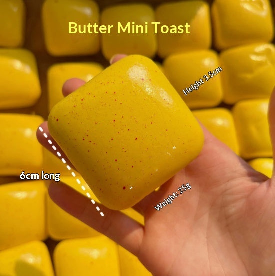 Butter-yellow mini toast squishy squeeze toy with crumb specks, held in hand