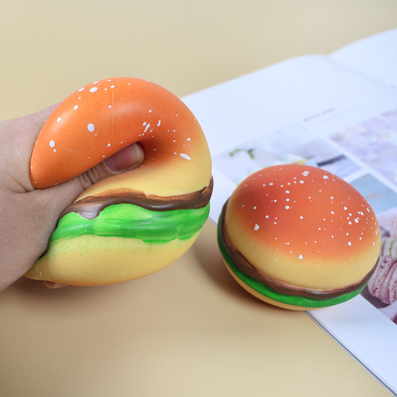 Burger squishy stress relief ball with orange bun, green lettuce, and brown patty in hand
