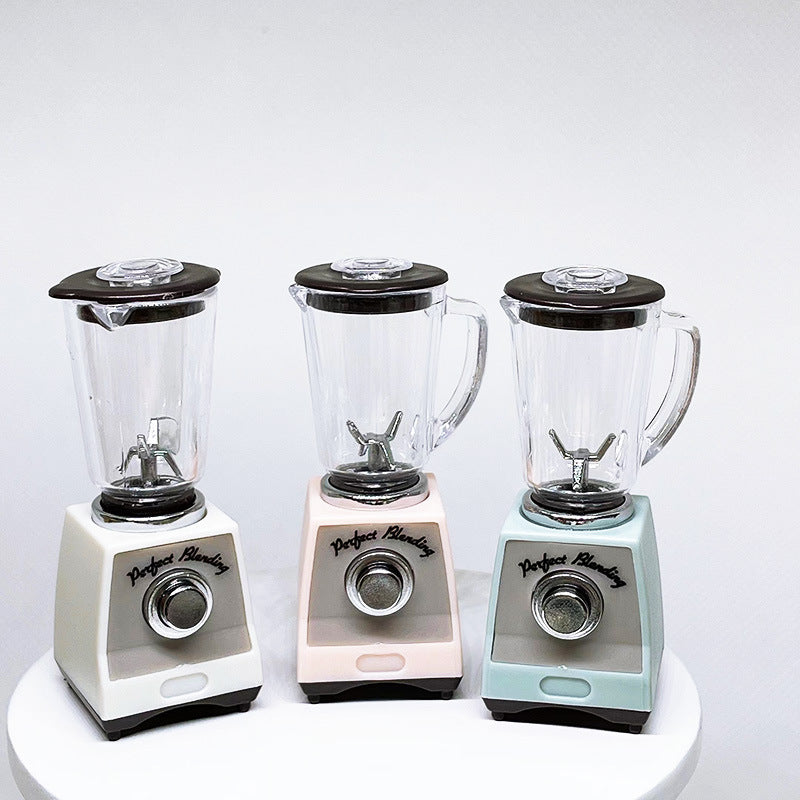 Pink toy blender with clear jar and black base, front dial and chrome cross blade