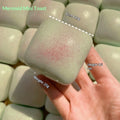 Squishy mini toast squeeze toy in pale green with speckles, held in hand