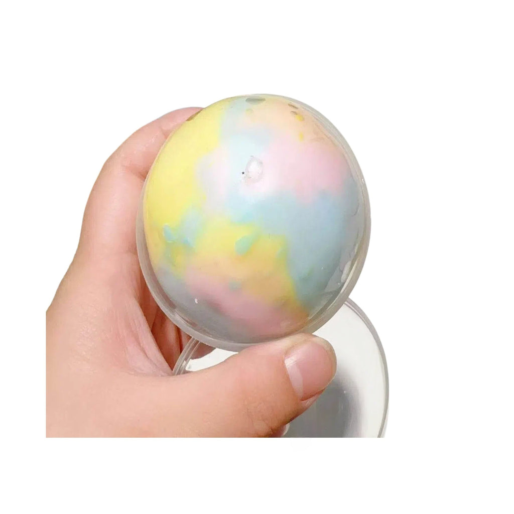 Pastel swirled crispy sphere stress-relief squeeze toy, held in one hand