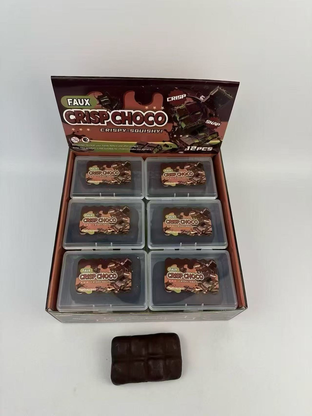 Dark brown rectangular squeeze toy with boxed set in gray tray compartments