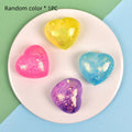 Glitter heart-shaped squishy squeeze toys in yellow, pink, purple, and blue