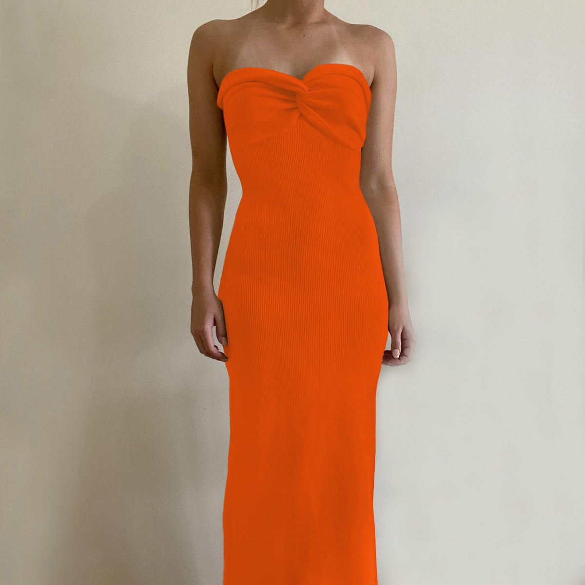 Off-shoulder knit wrap dress in vivid orange with knotted bust detail, long silhouette