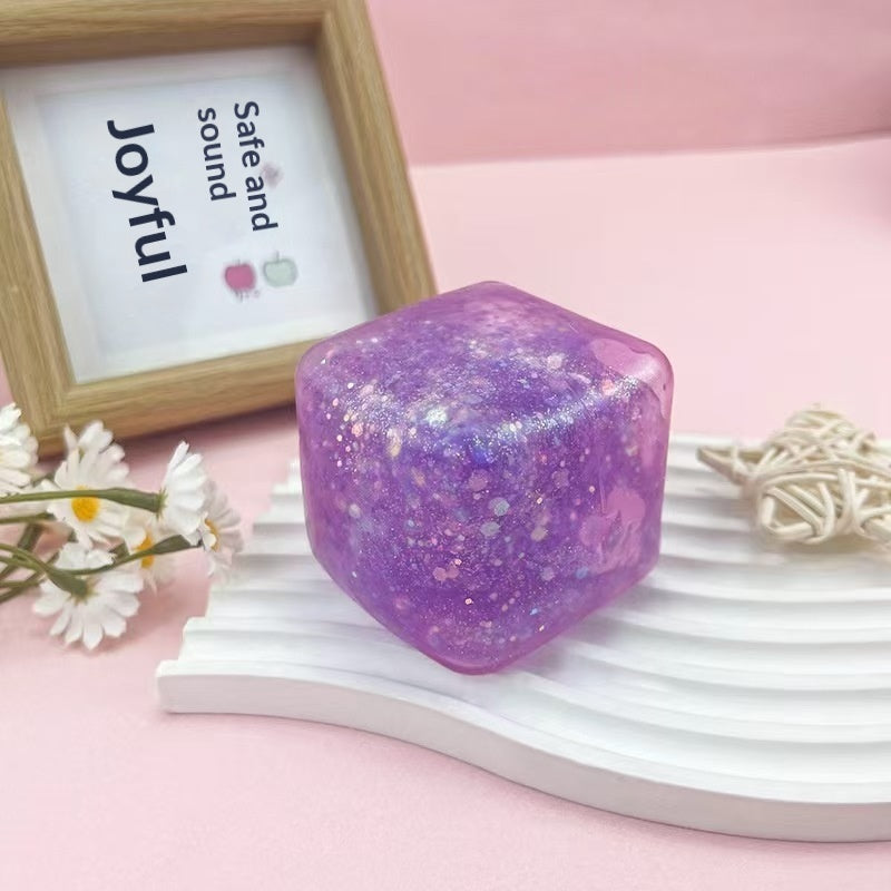 Purple glitter cube squeeze stress-relief toy, glossy translucent sides.