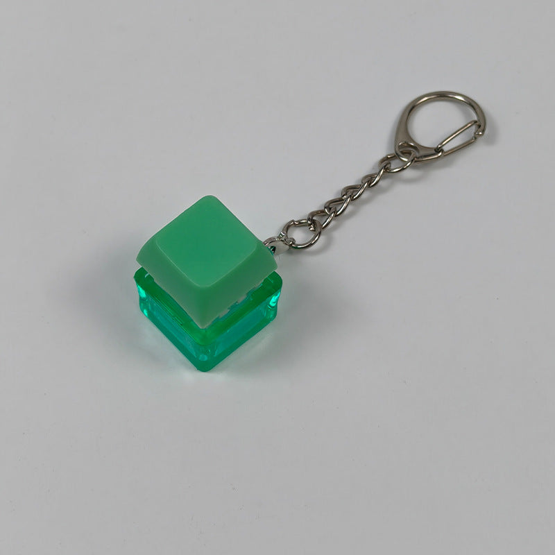 Green cube stress-relief keychain toy with finger-popping button and metal chain