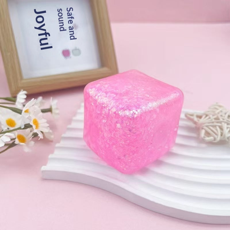 Pink water-cube stress-relief squishy toy with glitter speckles, translucent
