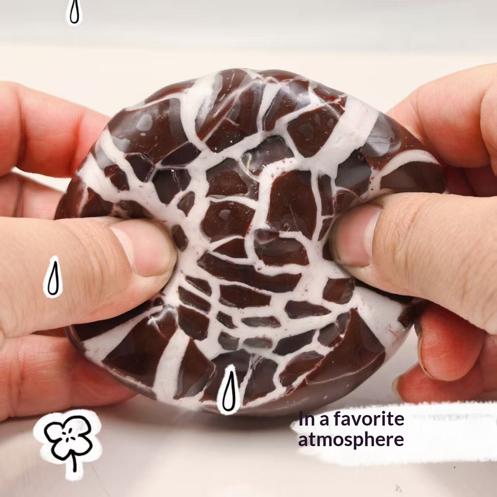 Chocolate-style crunchy ball stress toy with dark brown and white marbled cracks