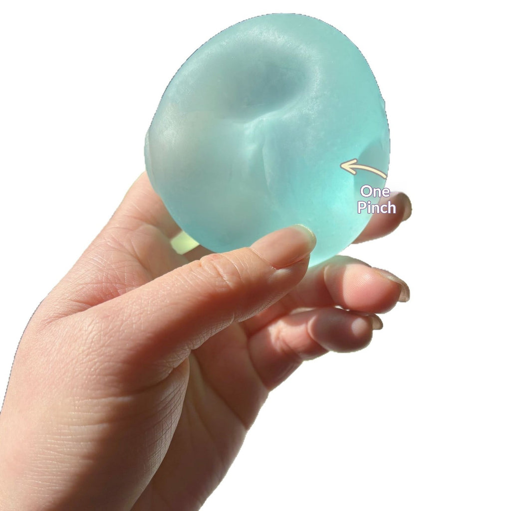 Translucent round squishy candy squeeze toy, light blue, pinched texture