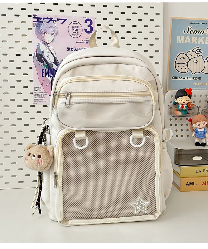 Cream large capacity nylon backpack with front zip pocket, mesh panel, and star badge