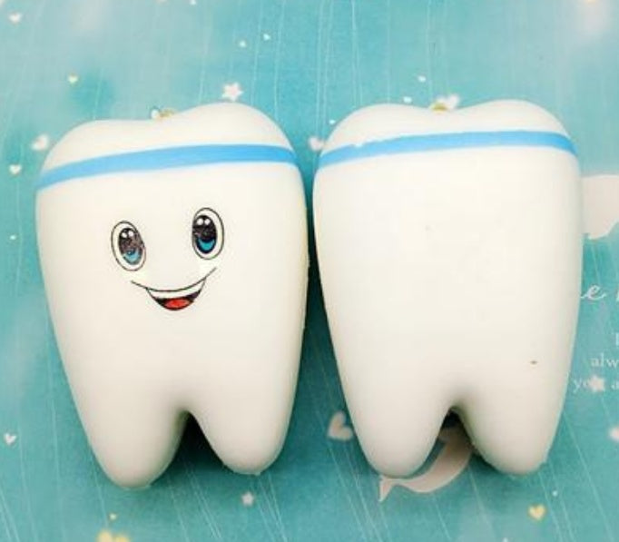 Slow-rising squishy toy white tooth with blue stripe and smiling cartoon face