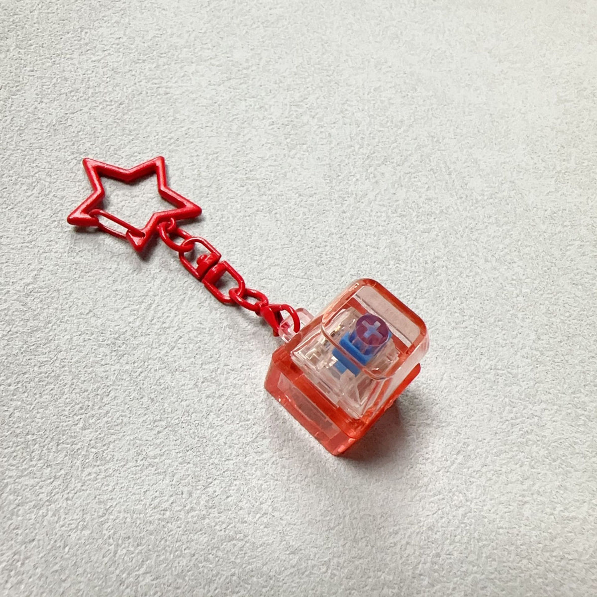 Red star charm mechanical key stress-relief toy with clear press piece and chain
