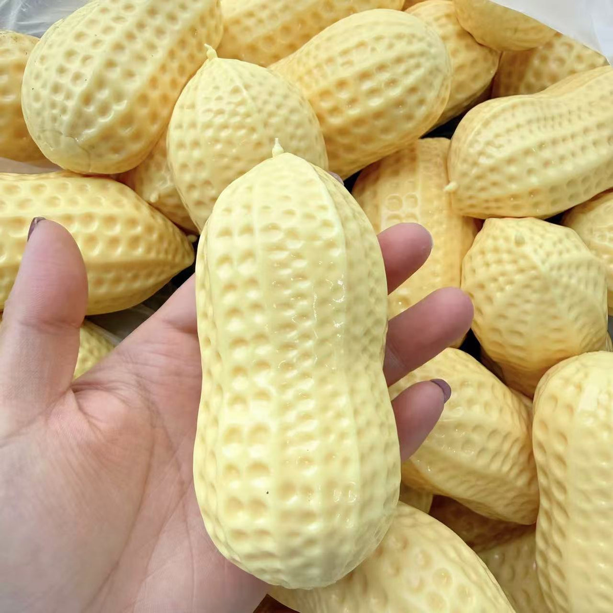 Yellow peanut squeeze stress toy with bumpy texture held up