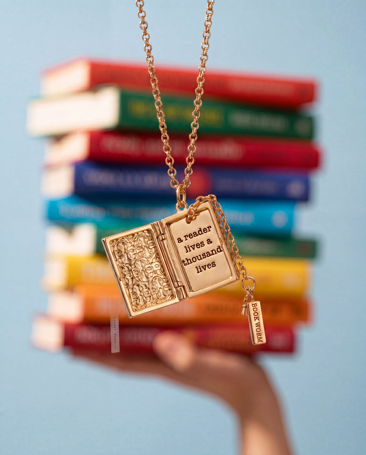Gold book club locket pendant with open-book face and “BOOK WORM” charm
