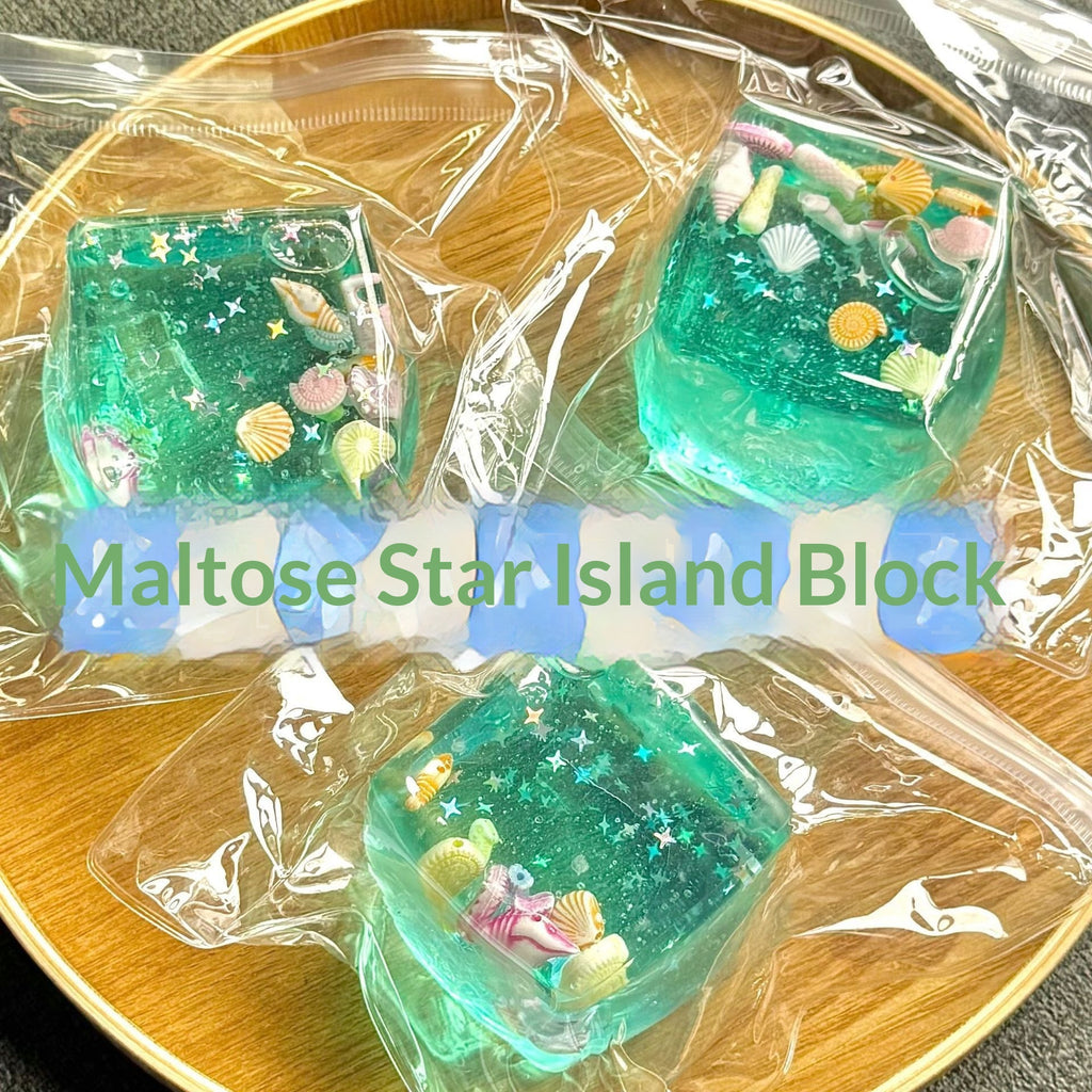 Set of three translucent aqua blue squeeze cubes with seashell and starfish designs in bag