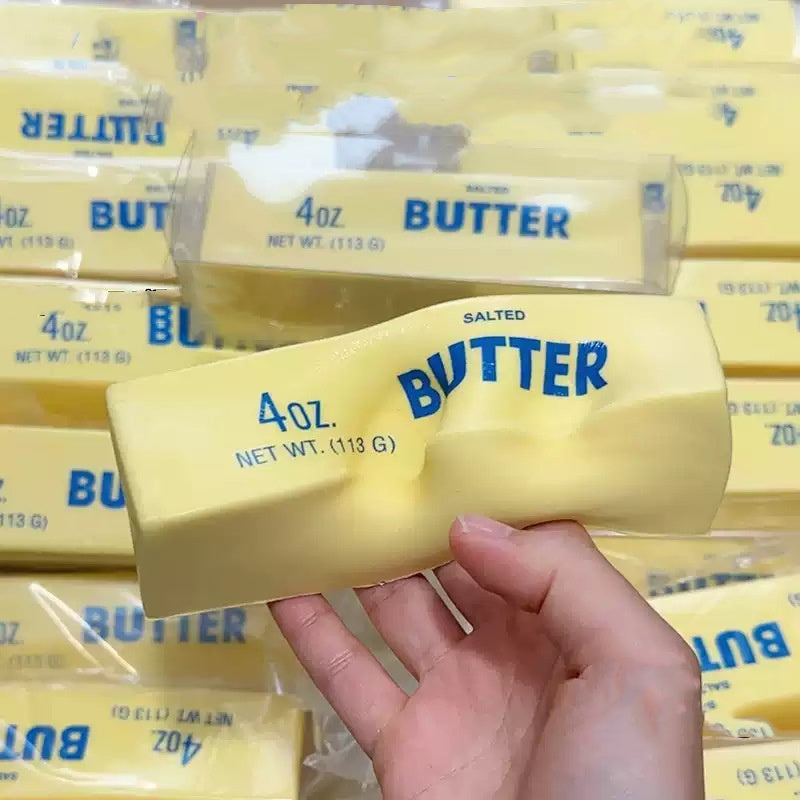 Yellow butter-shaped squishy stress-relief toy bar held in hand