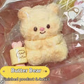 Silicone bear stress-reliever toy, pale yellow with dot eyes and red nose, in packaging