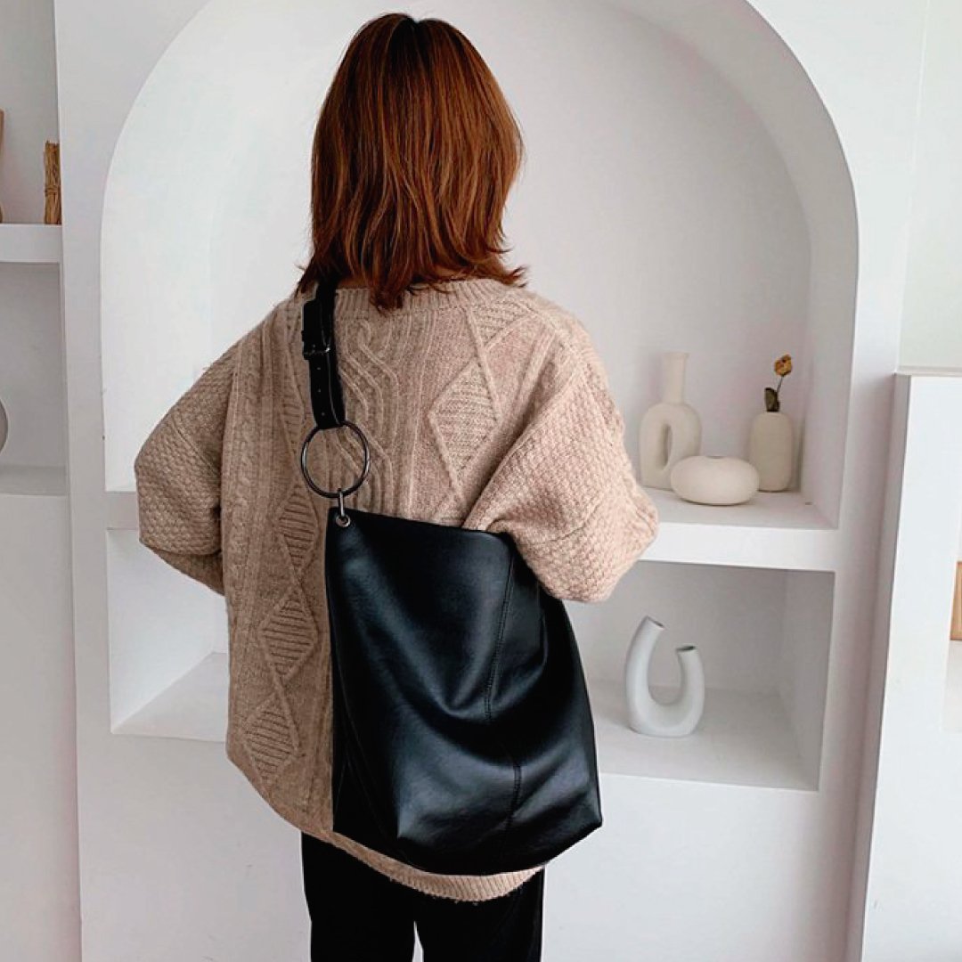 Black shoulder bag with ring strap hardware and slouchy top zipper silhouette