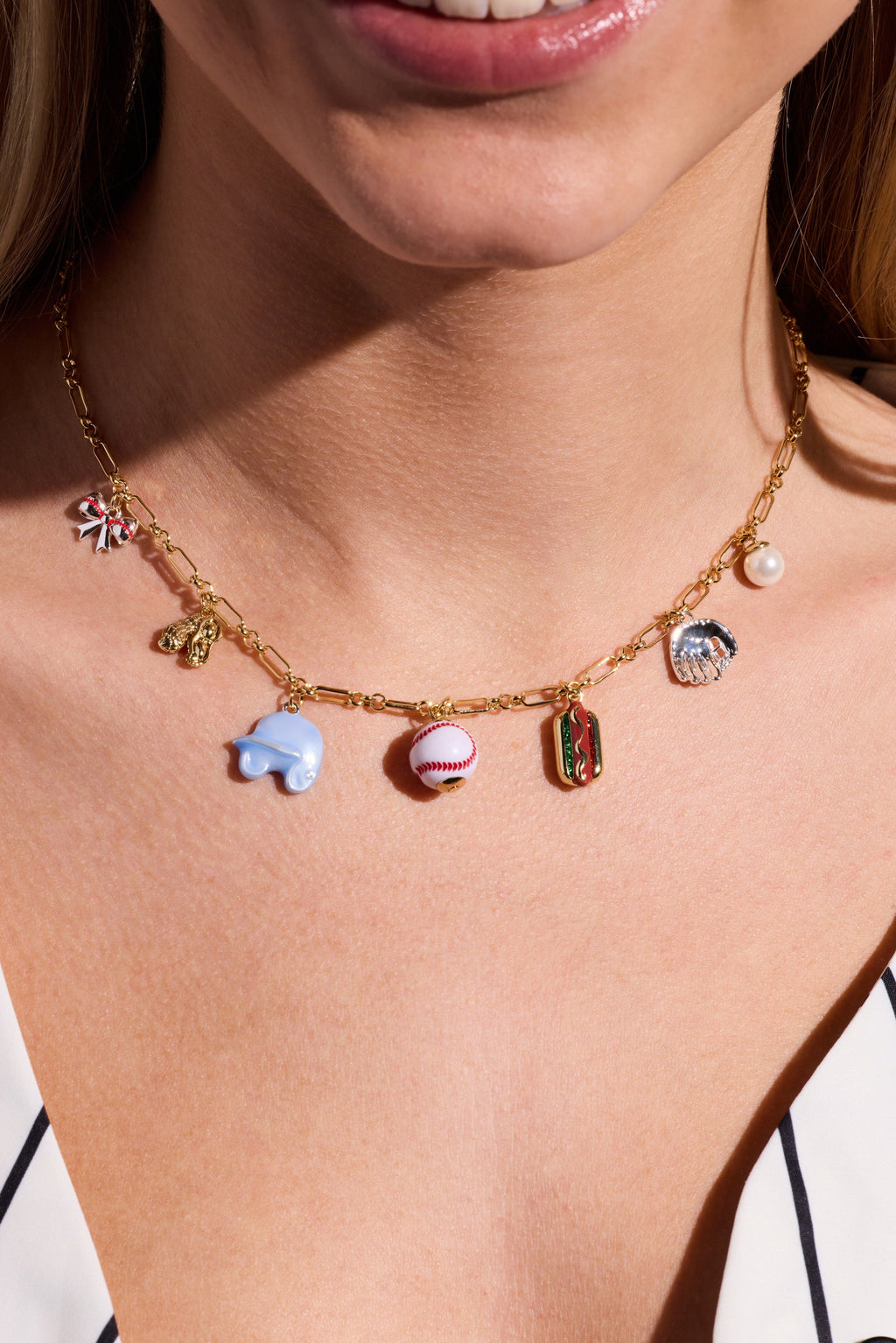 Gold two-tone charm necklace with pearl and baseball, blue bear, hot dog and cap charms