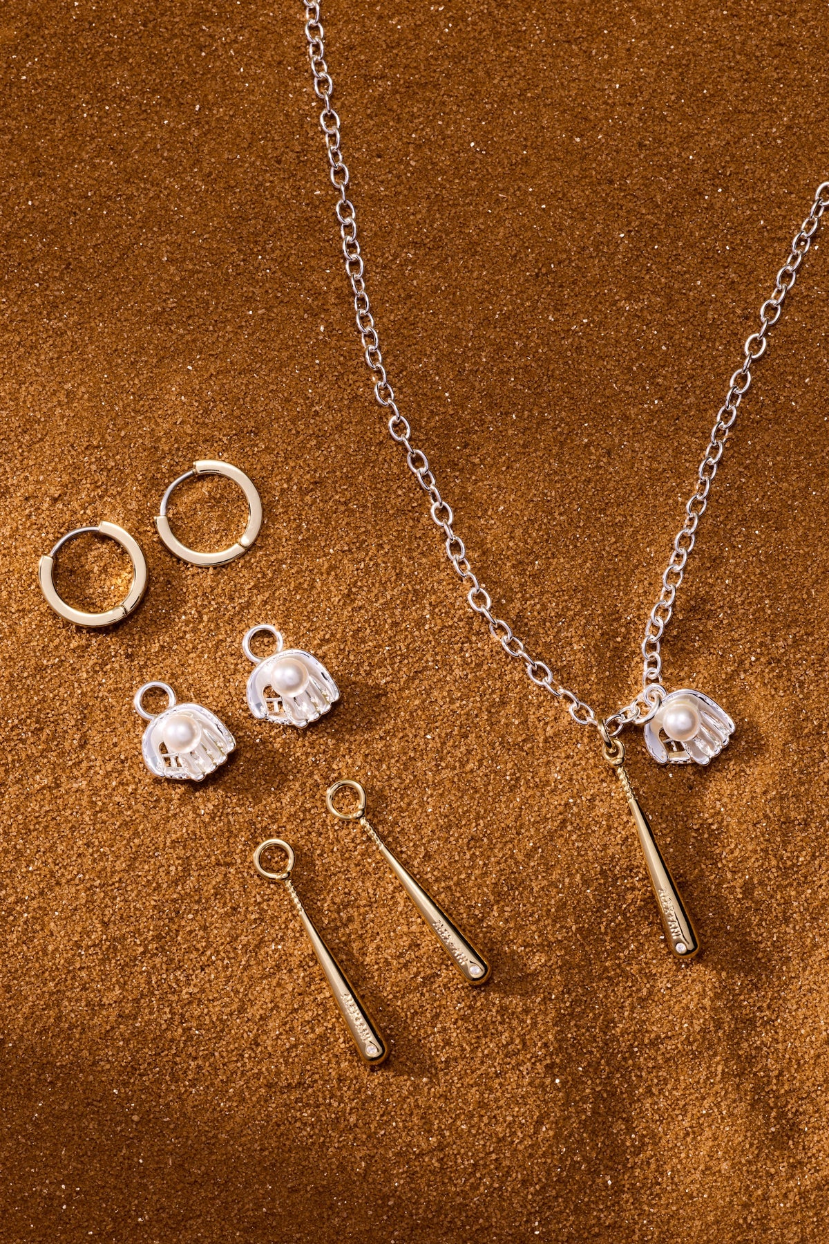 Two-tone pendant necklace with silver chain, helmet charms, and gold bat drop accents