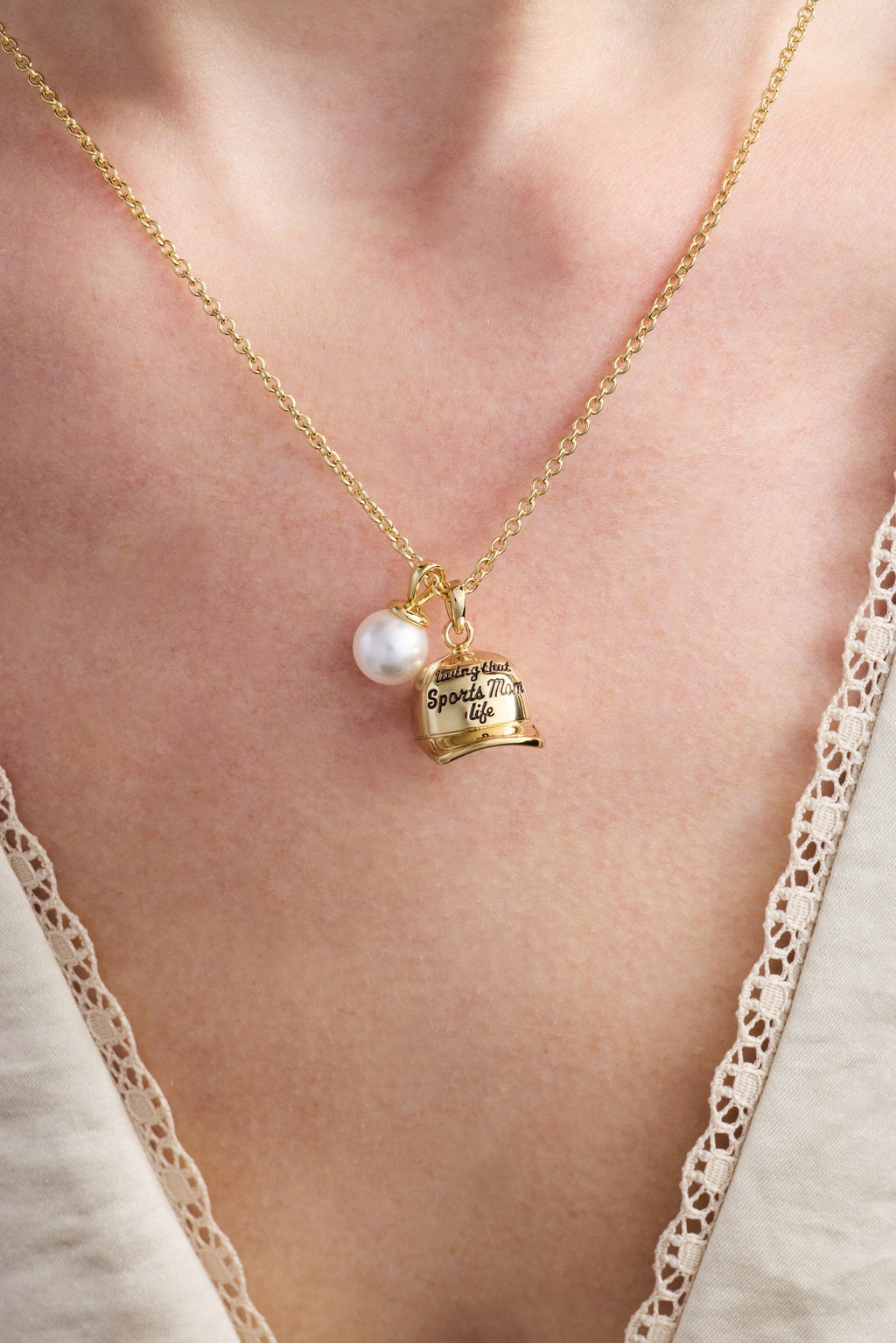Gold baseball charm necklace with pearl bead and cap pendant on neckline