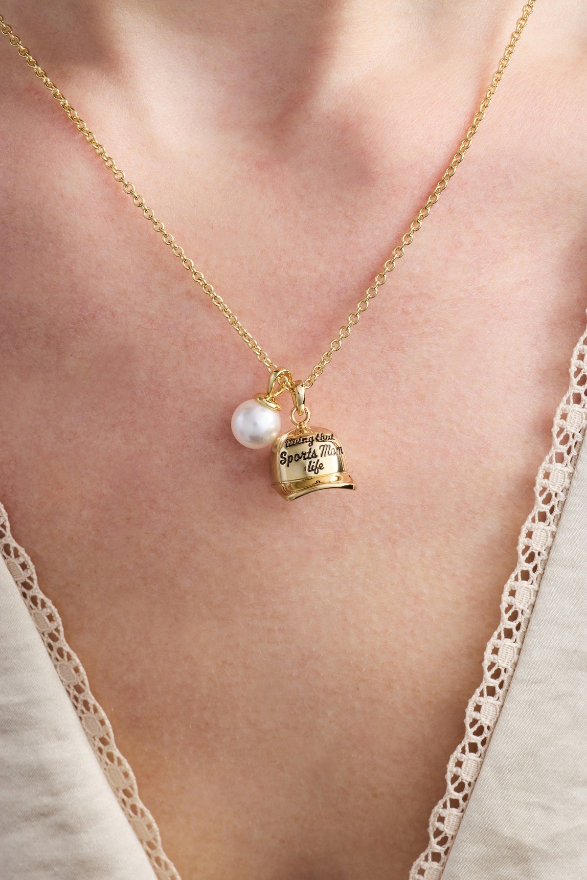 Gold baseball charm necklace with pearl bead and cap pendant on neckline