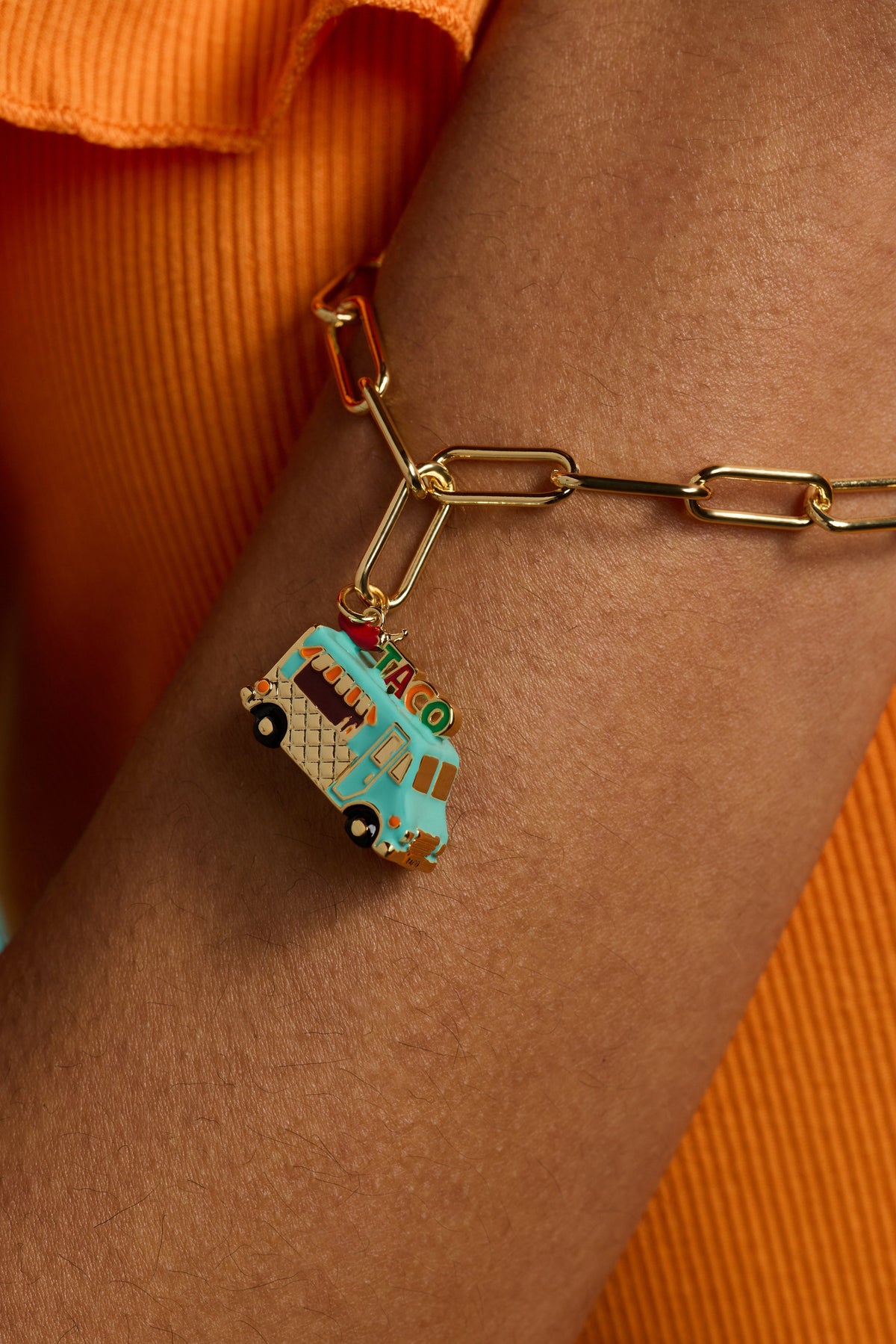 Gold toggle bracelet on wrist with taco truck charm and linked chain