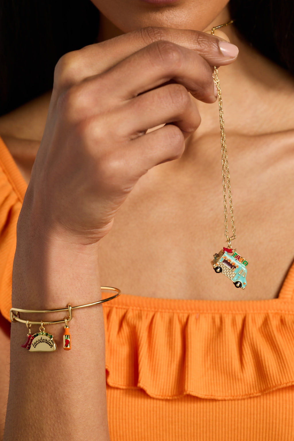 Gold taco truck locket necklace worn with taco truck pendant and dangling bottle charm.