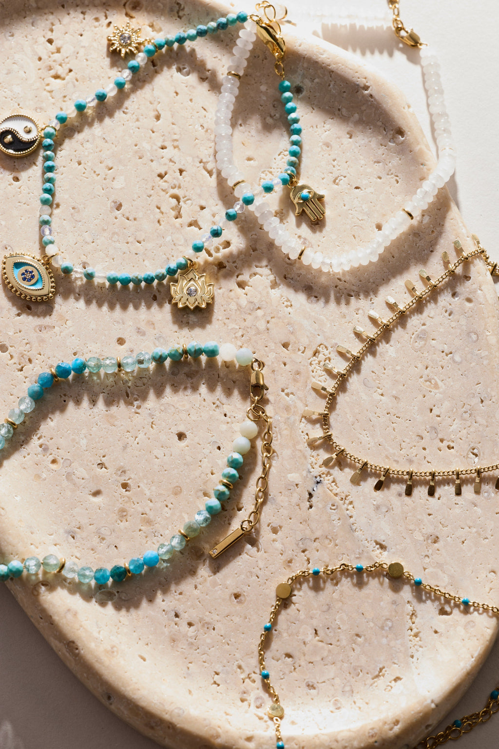 Turquoise bead charm anklets with evil-eye and hamsa charms on stone plate