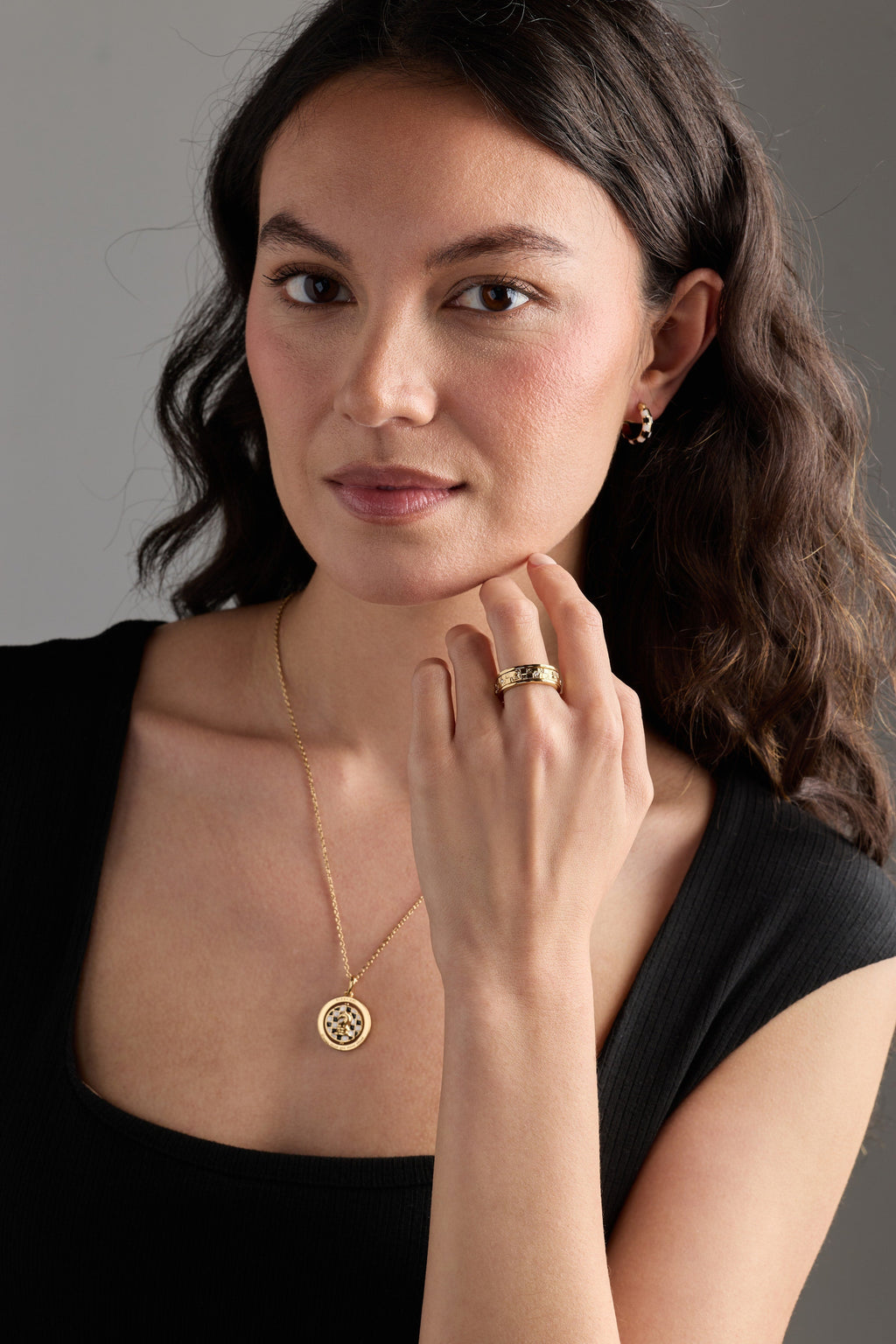 Gold chess spinner pendant necklace worn on a model, round crystal halo pendant
