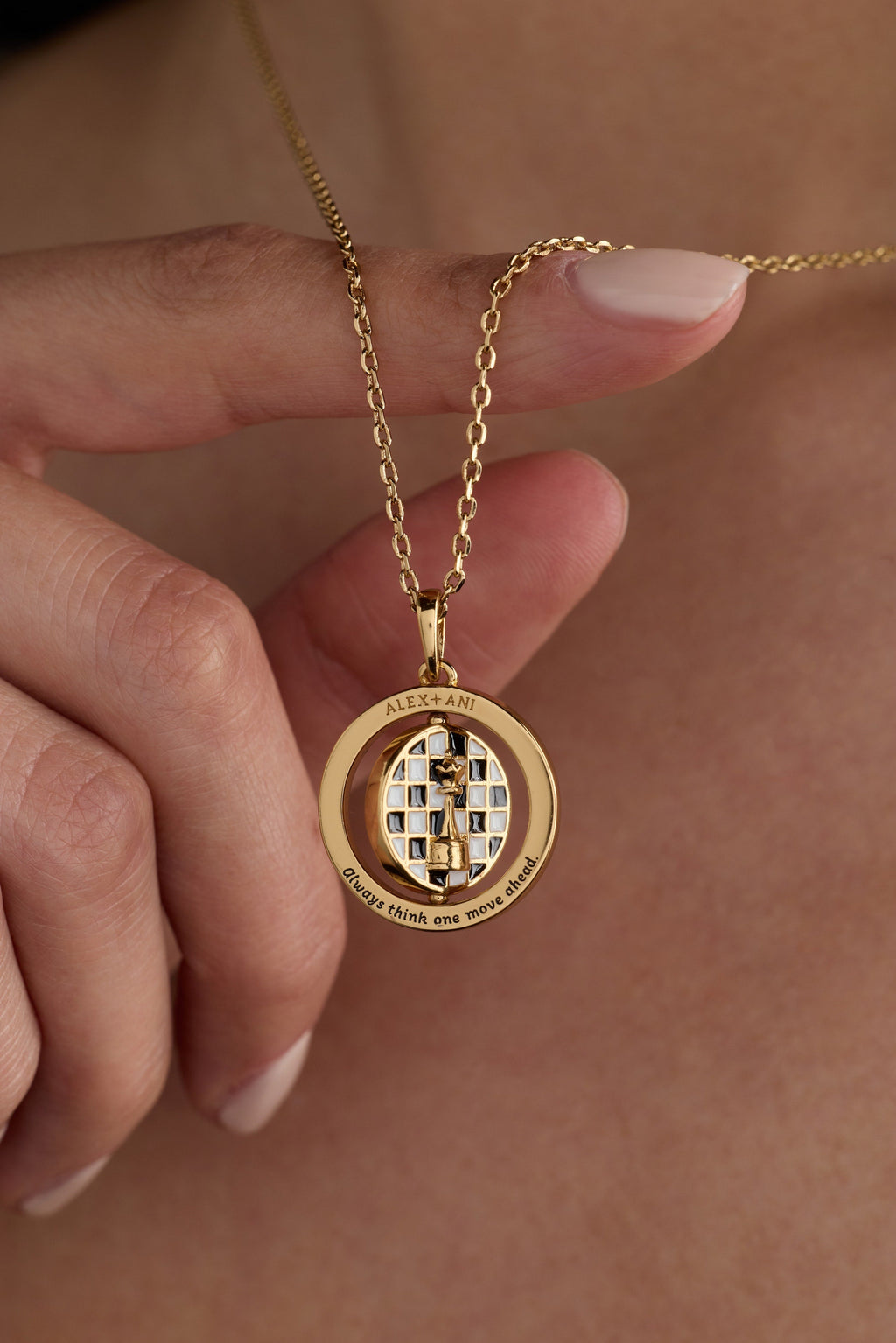Gold chess spinner pendant with rotating round center and engraved motto ring