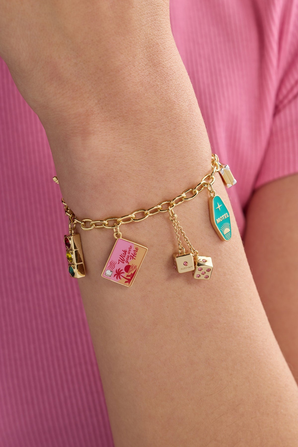 Gold charm bracelet on arm with four colorful rectangular card charms