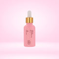 Pink perfume fragrance oil bottle with gold cap and dropper, front label