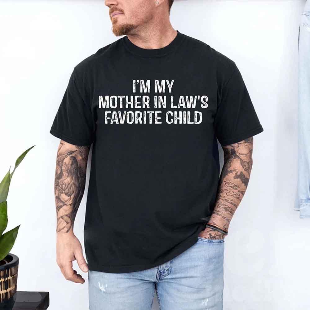 Black crew-neck T-shirt worn by a man; reads “I’M MY MOTHER IN LAW’S FAVORITE CHILD”.