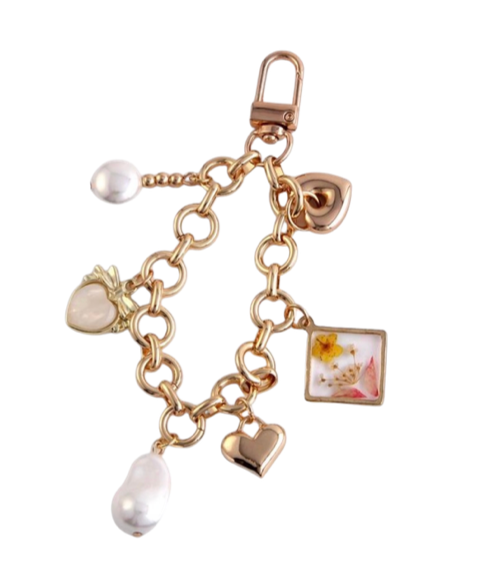 Golden bag charm with clasp chain, pearl drops, hearts, and floral photo square