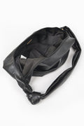 Black faux leather hobo bag open to show dark lining and interior pocket