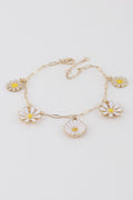 Gold-tone charm bracelet with white daisy flowers and yellow centers